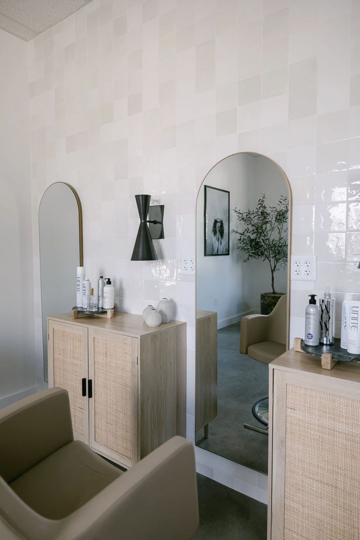 a living room with two chairs and a mirror on the wall next to each other