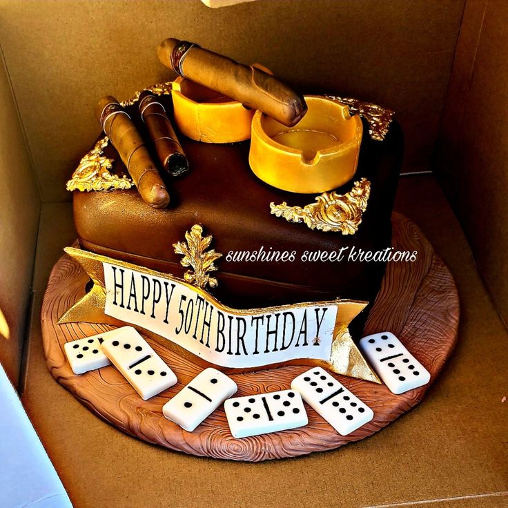 a birthday cake in the shape of a suitcase with dice and cigars on it