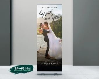 a couple kissing in front of a welcome sign for their wedding day, with the words happily married on it