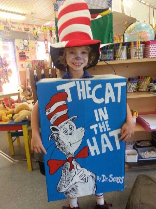 the cat in the hat is holding up a sign that says, the cat in the hat