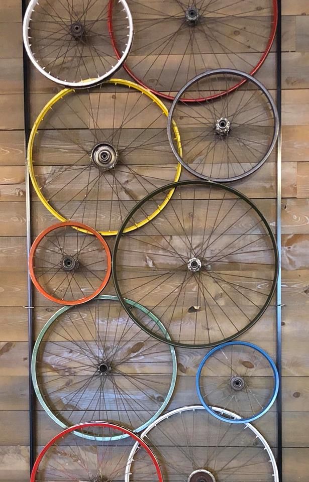 several different types of bicycles are hanging on the wall in front of wooden planks