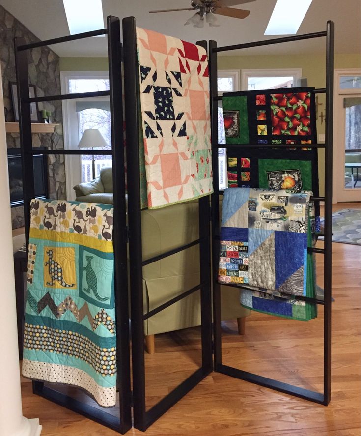 a room divider with quilts hanging on it