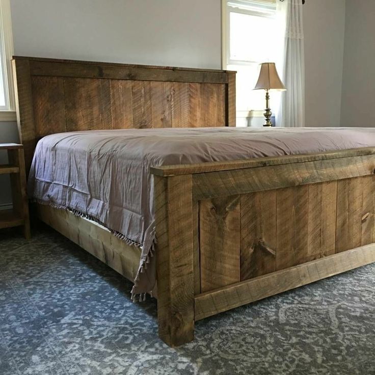 a bed made out of wood with a wooden headboard and foot board on the side