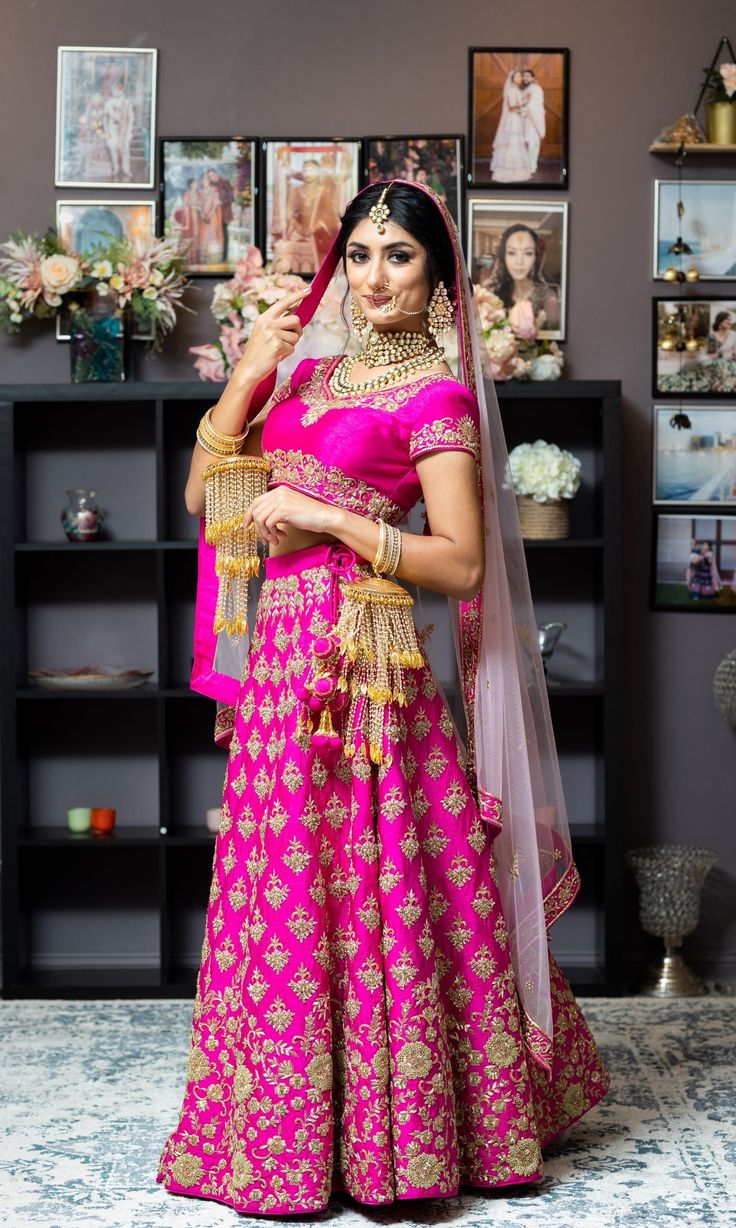 This beautiful set has an appeal of its own. Not just the bright magenta color, but the antique gold Zardozi work makes it so regal in look. Fully embroidered skirt paired with a blouse with embroidery on neckline and hemlines. Net dupatta with heavy borders and scattered bootis adds to the elegance. Embroidery is done with dabka, nakshi, zari french knots, and rich zircons. You have the option to change the color of the garment and make it according to your requirements. Please contact our Sale Reception Art Silk Dupatta With Tilla Detail, Art Silk Dupatta With Tilla For Reception, Kundan Gown With Traditional Drape For Ceremonies, Traditional Kundan Gown For Ceremonies, Pink Resham Embroidery Sets For Traditional Ceremonies, Resham Embroidery Lehenga For Traditional Ceremonies, Pink Kundan Dupatta For Traditional Ceremonies, Gold Anarkali Choli For Traditional Ceremonies, Gold Gown With Pallu For Traditional Ceremonies