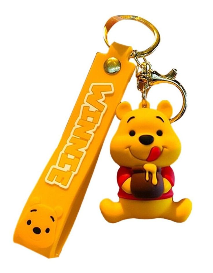 winnie the pooh keychain is next to a small yellow box with a bear on it