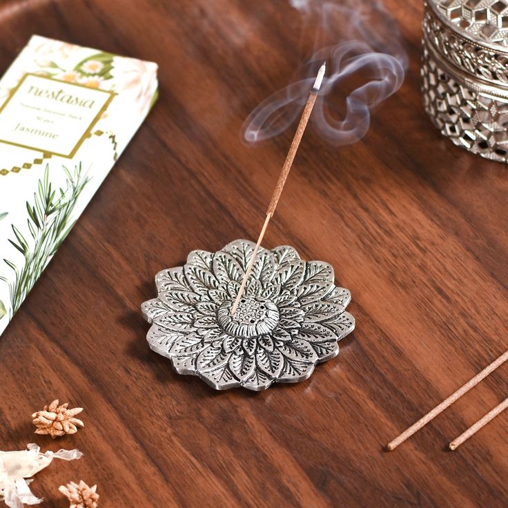 a wooden table topped with incense sticks and an ornament on top of it