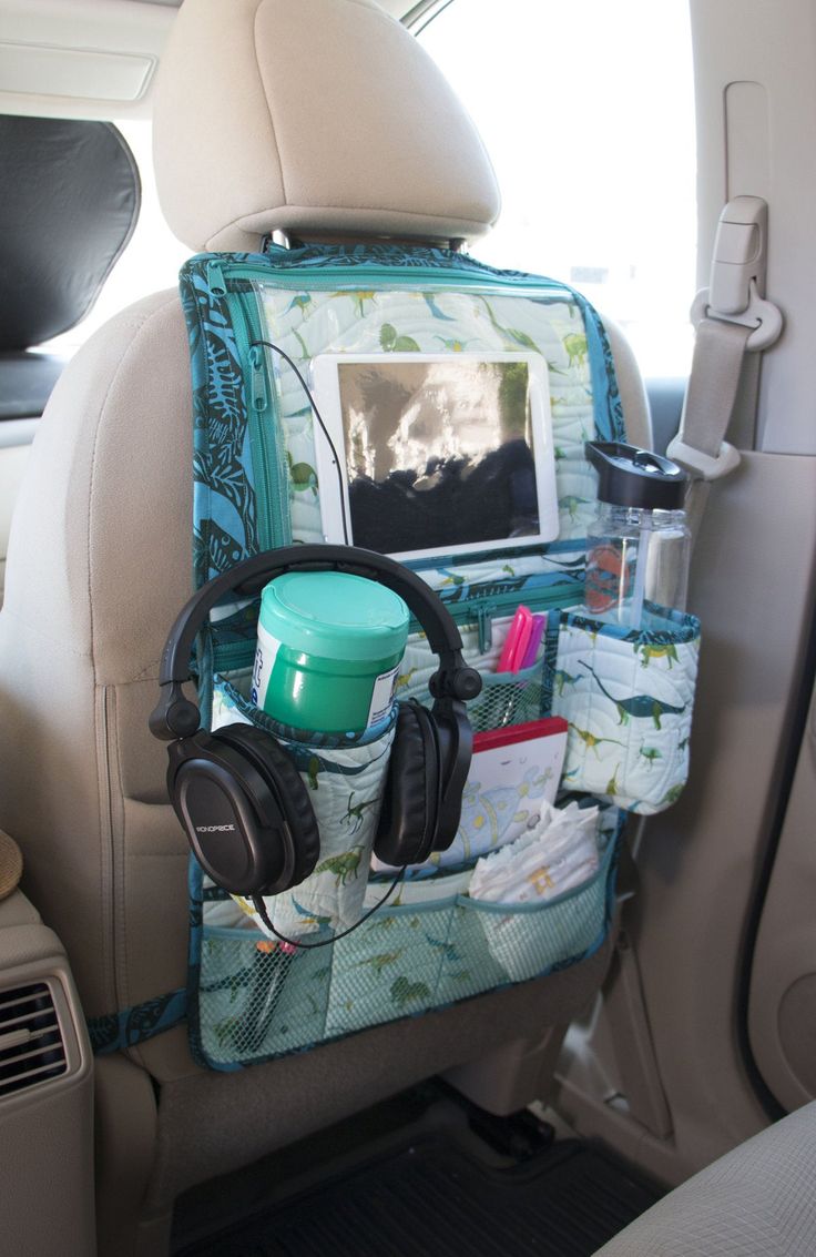 the back seat of a car with headphones and other items in it's holder