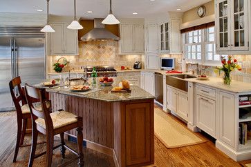 a large kitchen with white cabinets and wooden floors