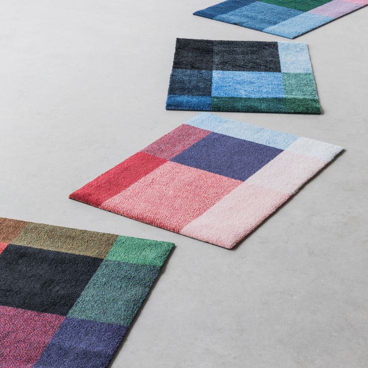 three different colored rugs laying on the floor next to each other, one is multicolored