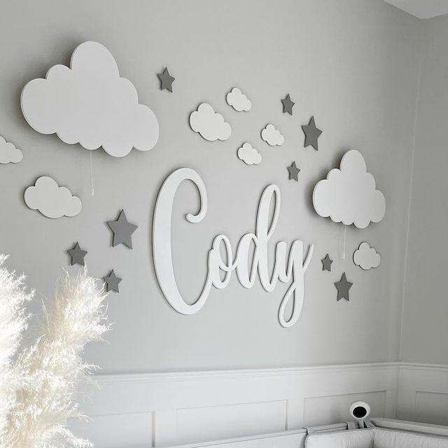 a baby's room with clouds, stars and the word c is displayed on the wall