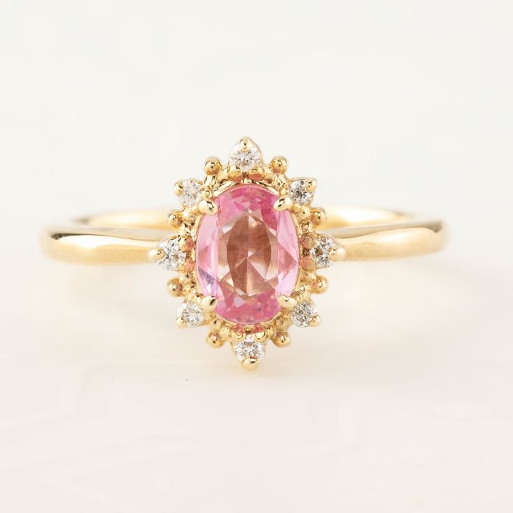 This is made to order ring. Beautiful unheated pink sapphire from Madagascar, weight ranges from 0.60 to 0.7ct, 7x5mm, eye clean 0.08ctw., G color SI clarity accent diamonds Band width: approx. 1.9mm High profile setting, easy stacking with a straight band Made of recycled solid 14k gold Our Dedication All our jewelry is designed and created by Kat with great attention to details and the entire production from casting, stone setting to finishing takes place in New York, USA. All gemstones used i Pink Sapphire Promise Ring With Halo Design, Classic Pink Cluster Ring With Halo Setting, Pink Oval Sapphire Ring With Halo Setting, Pink Oval Cluster Ring Fine Jewelry, Pink Oval Cluster Ring With Center Stone, Pink Oval Cluster Promise Ring, Pink Oval Diamond Ring With Halo Design, Pink Oval Halo Ring, Pink Sapphire Engagement Ring