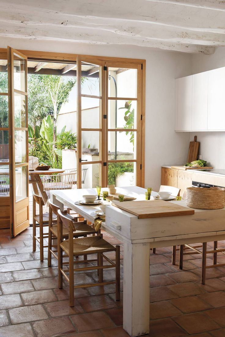 a kitchen with a table and chairs in front of a sliding glass door that leads to an outside patio