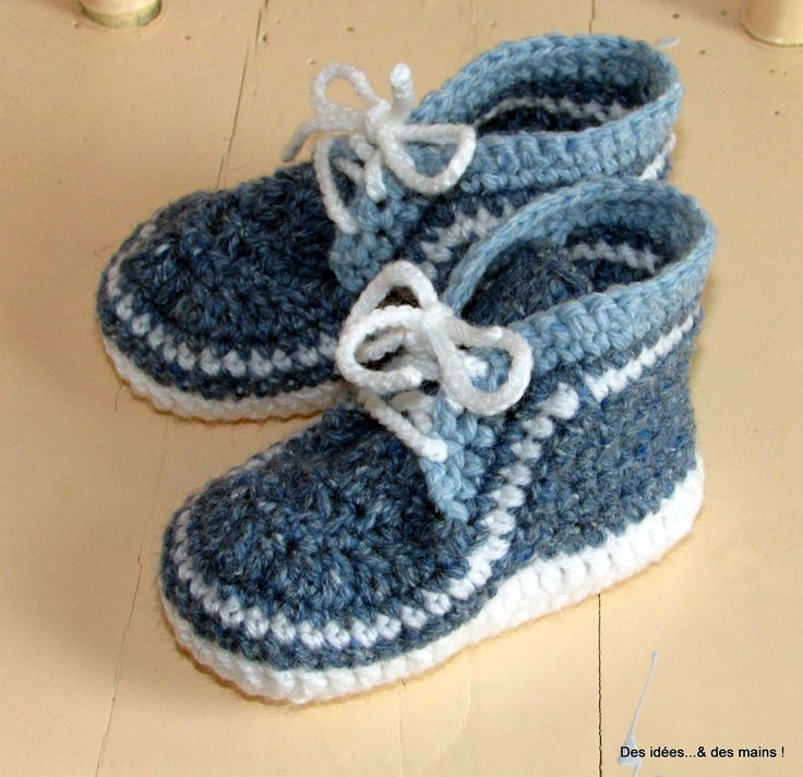 a pair of blue and white crocheted baby shoes