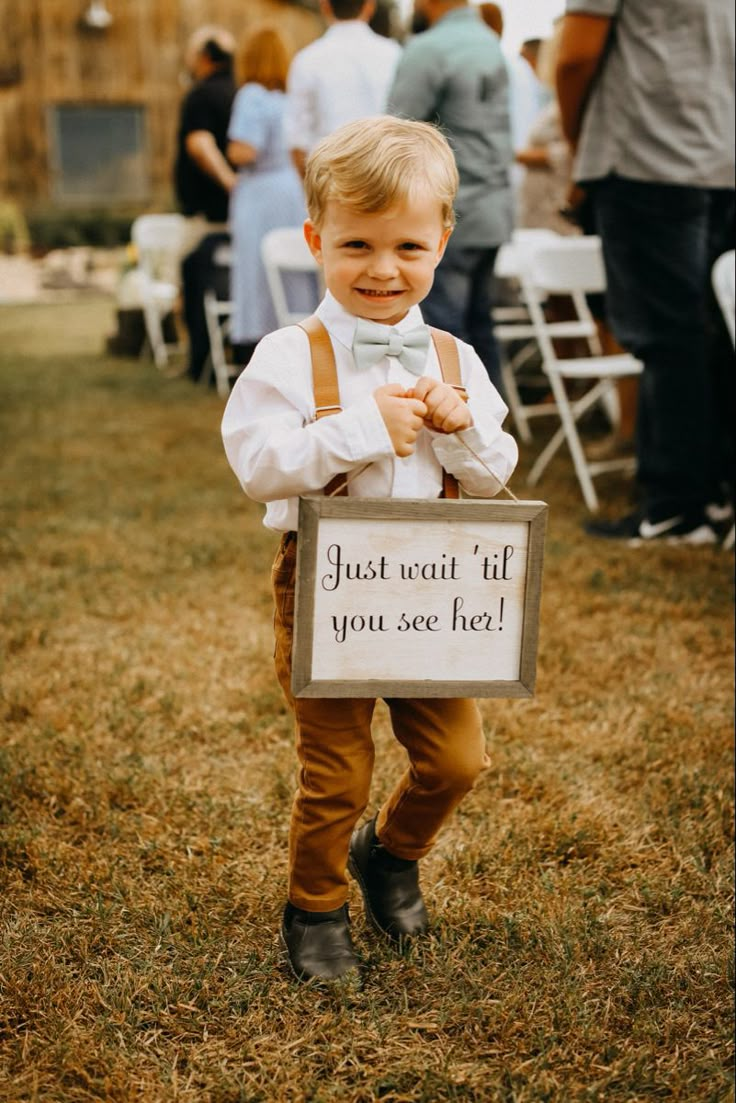 a little boy holding a sign that says just wait til you see me