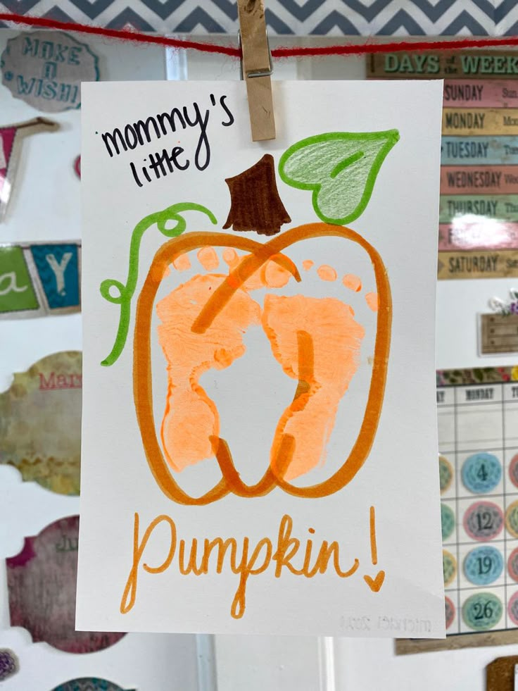 a paper sign hanging from a clothes line with magnets on it that says mommy's time pumpkin