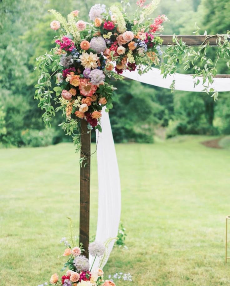 an outdoor ceremony setup with flowers and greenery