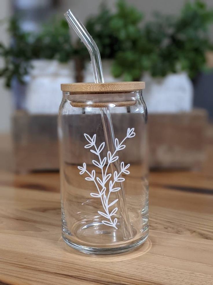 a glass jar with a straw in it sitting on a table