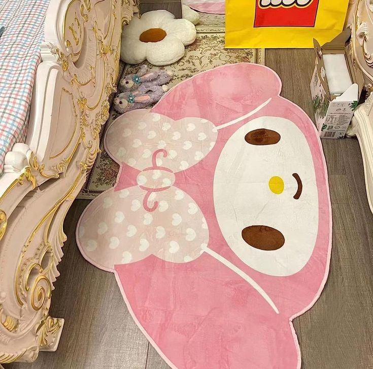 a pink teddy bear rug sitting on top of a wooden floor next to a bed