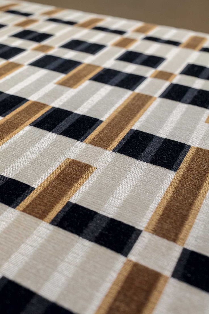 a checkered table cloth with brown and black squares on it's surface, close up