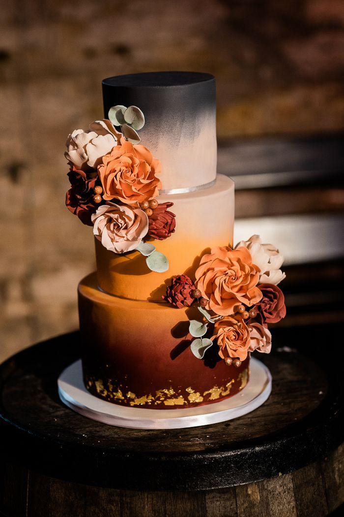 a three tiered cake with flowers on top