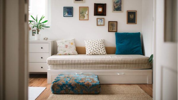 a living room filled with furniture and lots of framed pictures on the wall above it