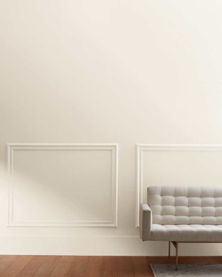 a white couch sitting in front of a wall