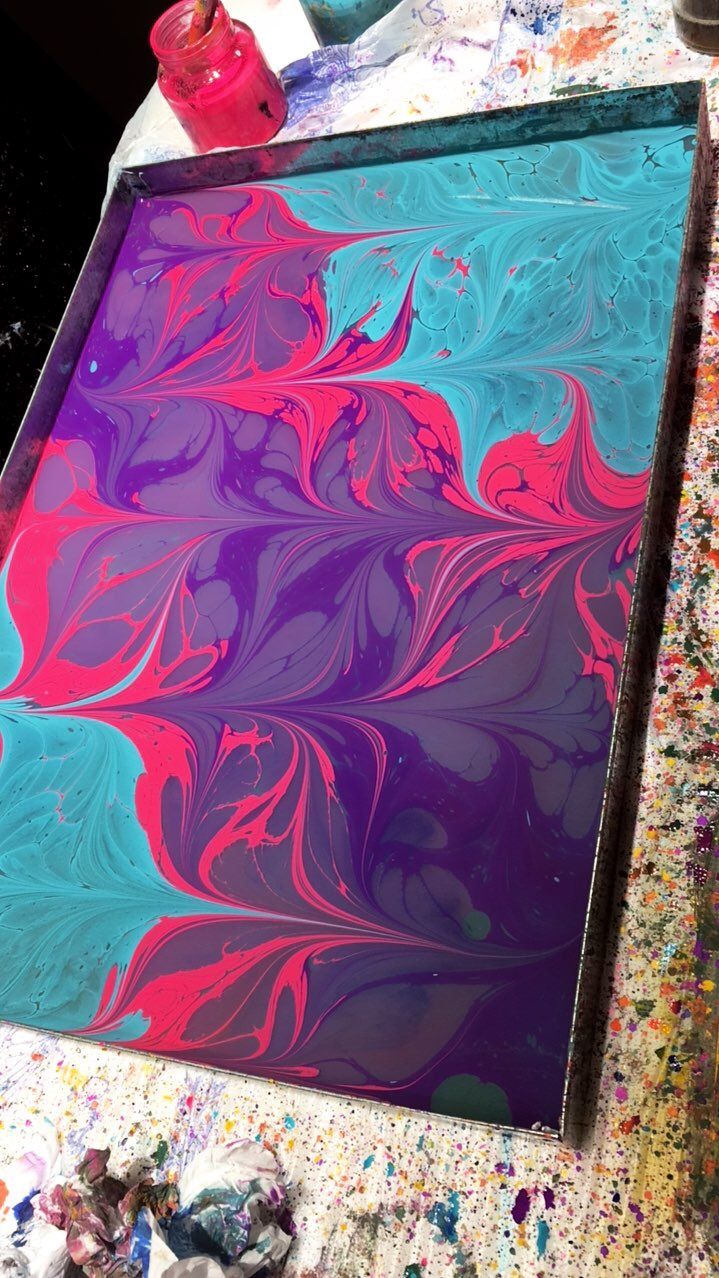 a painting is being displayed on a table with paint and sprinkles around it