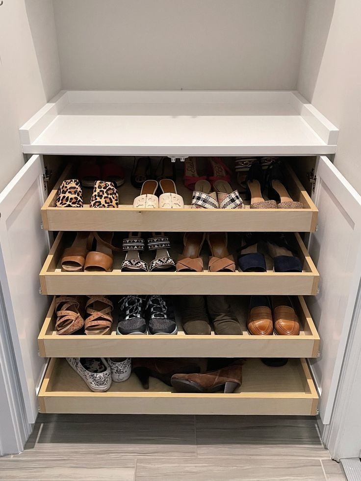 an open closet with several pairs of shoes on the bottom shelf and one pair of slippers on the bottom shelf