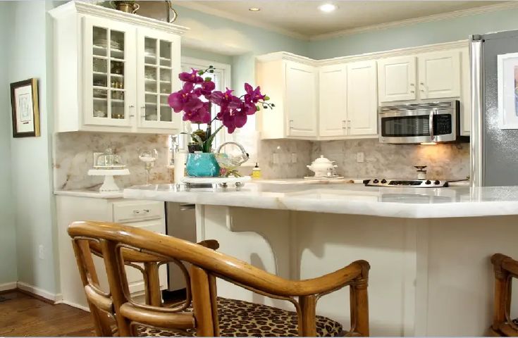 a kitchen with two chairs and a center island in front of a refrigerator freezer