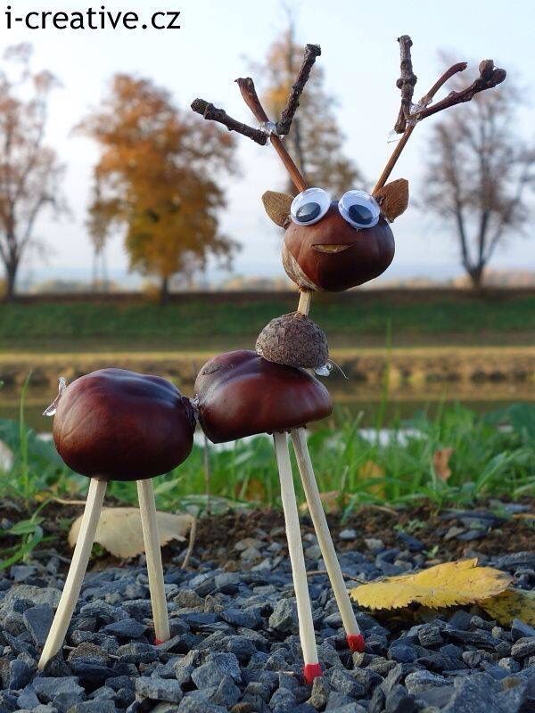 a close up of a statue of a reindeer on top of rocks with trees in the background