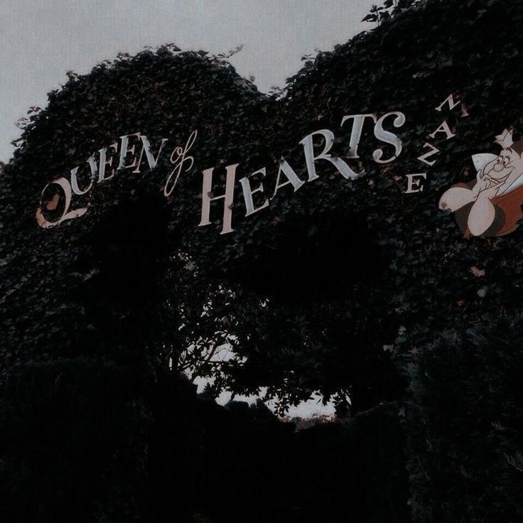 the queen of hearts theatre sign is covered in ivy