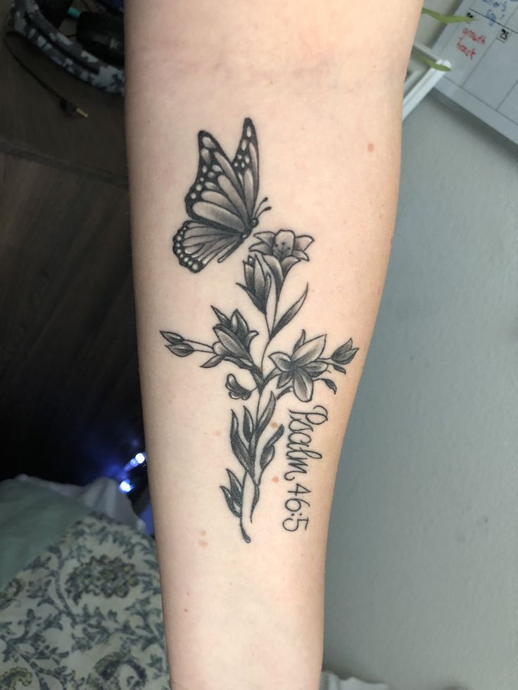 a butterfly and flower tattoo on the leg