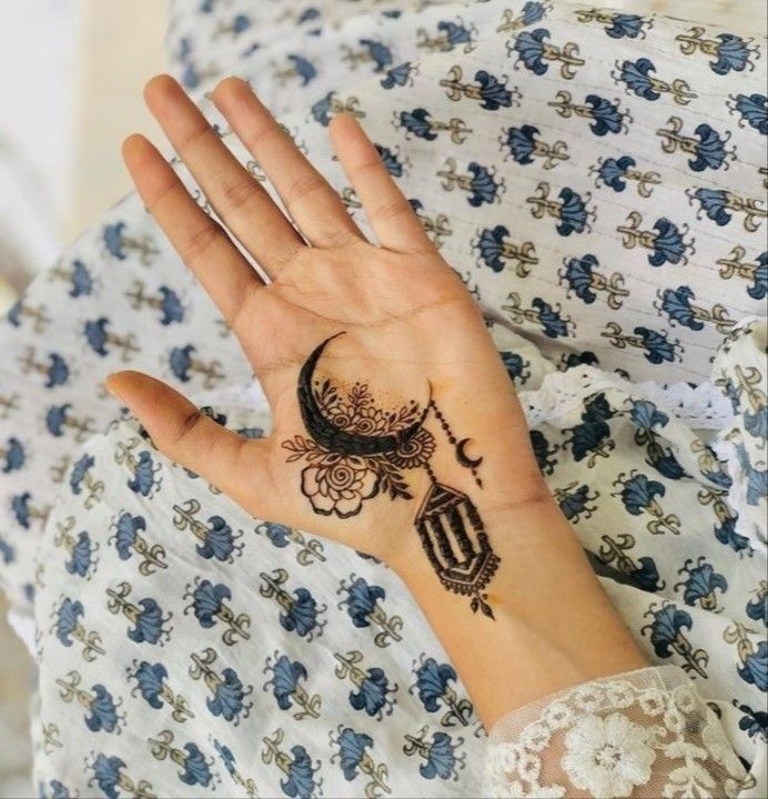 a woman's hand with a henna tattoo on her left wrist and an intricate design on the palm