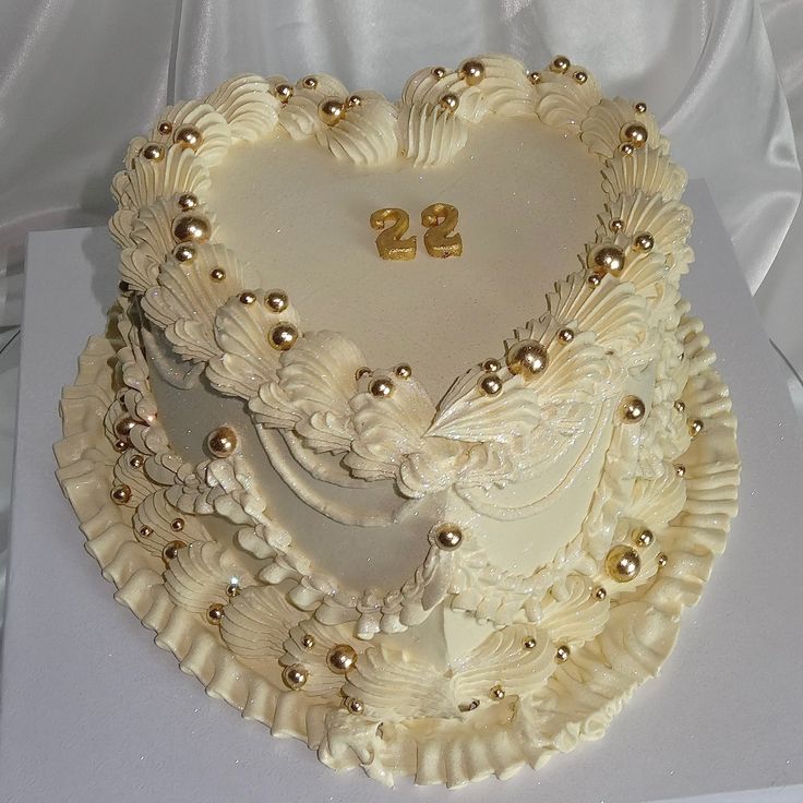 a heart shaped cake with gold decorations on it's sides and the number twenty two