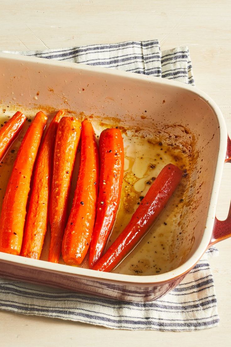 carrots and peppers in a casserole dish with seasoning on the side