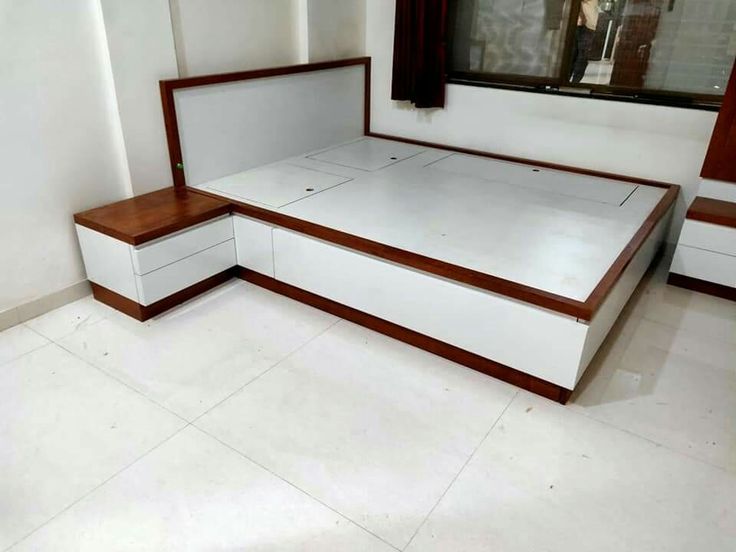 a white bed sitting in the middle of a room next to a wall mounted window