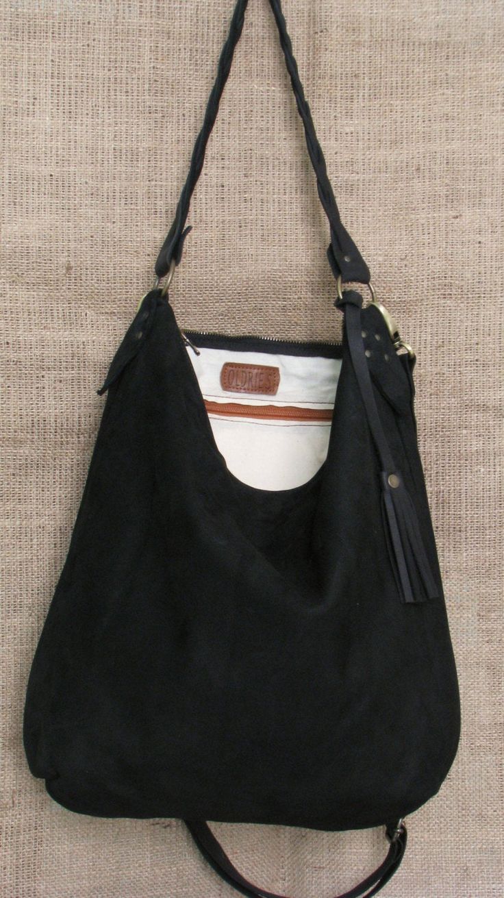 Handmade black suede hobo bag. This bag is unlined, inside there is a big cotton zipped pocket. The bag is closed with a zip The handle is an handmade leather braid. The sholder belt is removable and adjustable. This confortable hobo bag is very practical for any occasion. This bag is very large and soft and may contain many things. Features : - Black suede, - Unined, - Metal finishes are brass colored, - Closed with zip, - Inside zipped pocket, - Removable shoulder belt. Size : - Heigth 16 inch Suede Hobo Bag, Shoulder Belt, Leather Bag Women, Leather Bags Handmade, Leather Hobo Bag, Leather Hobo, Custom Bags, Metal Finishes, Brass Color