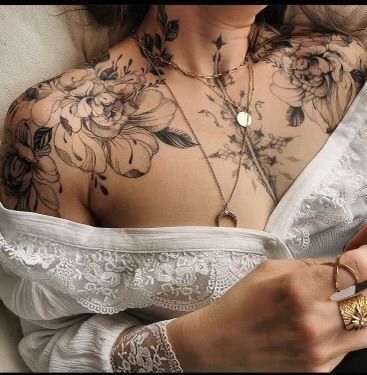 a woman with tattoos on her chest holding a knife