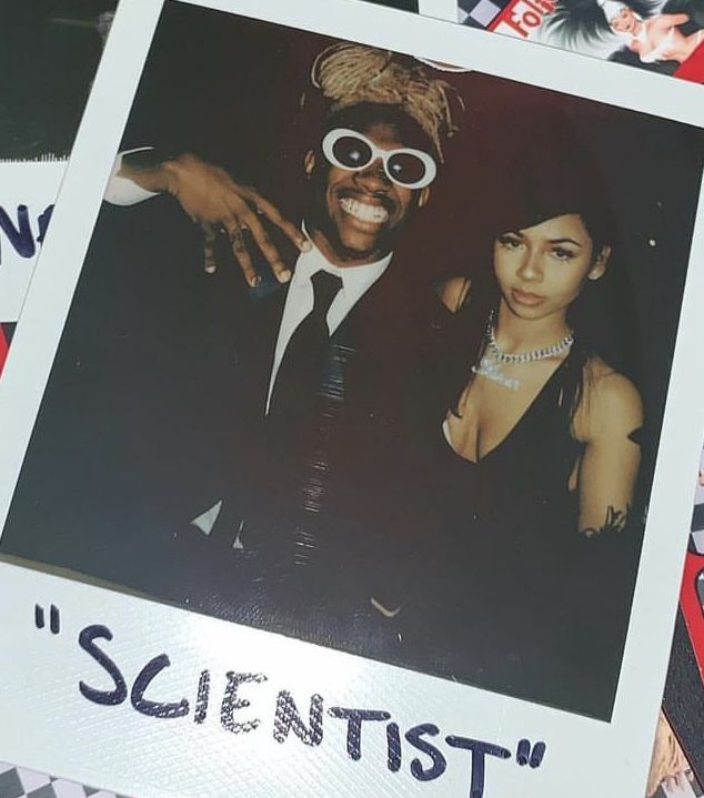 a man and woman are posing for a photo in front of some stickers with the word scientist on them