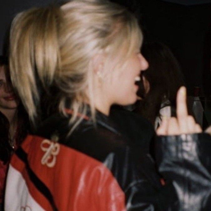 two women standing next to each other talking on cell phones