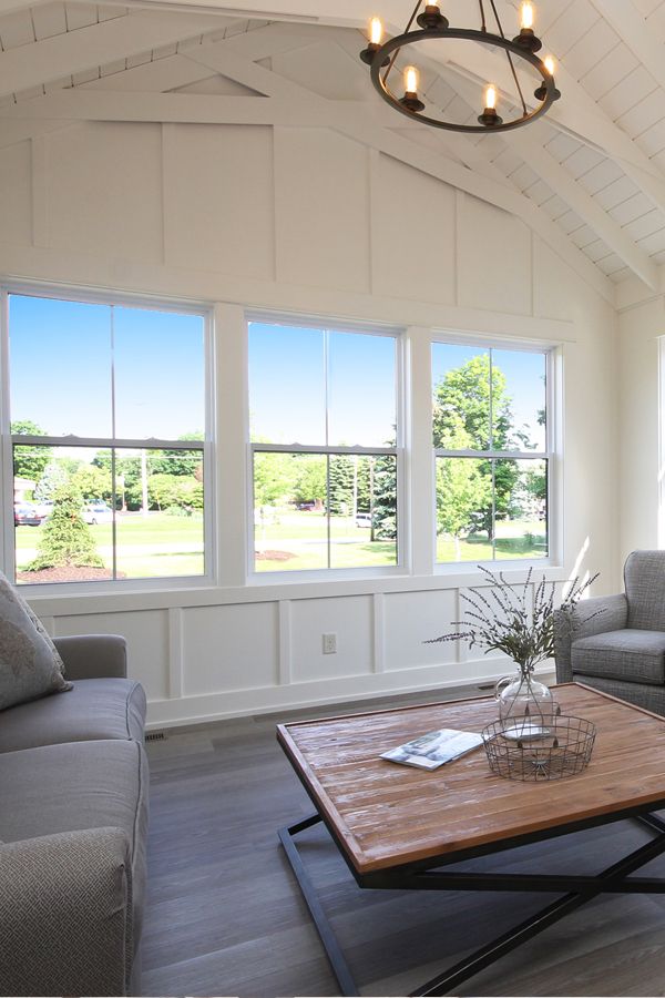 a living room with two couches and a coffee table in front of large windows