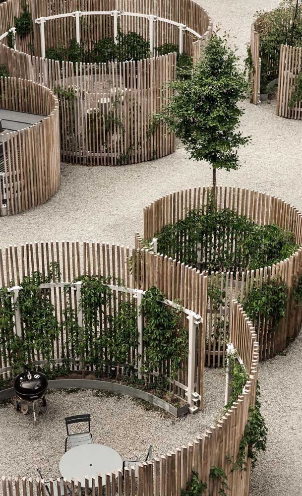 an outdoor seating area made out of wooden slats with trees in the center and benches around it