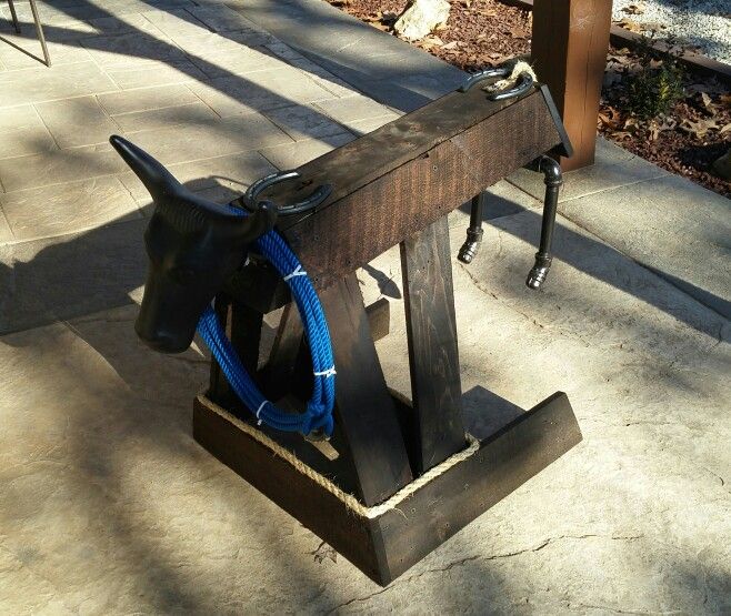 a wooden bench with a blue hose attached to it's end and on the ground