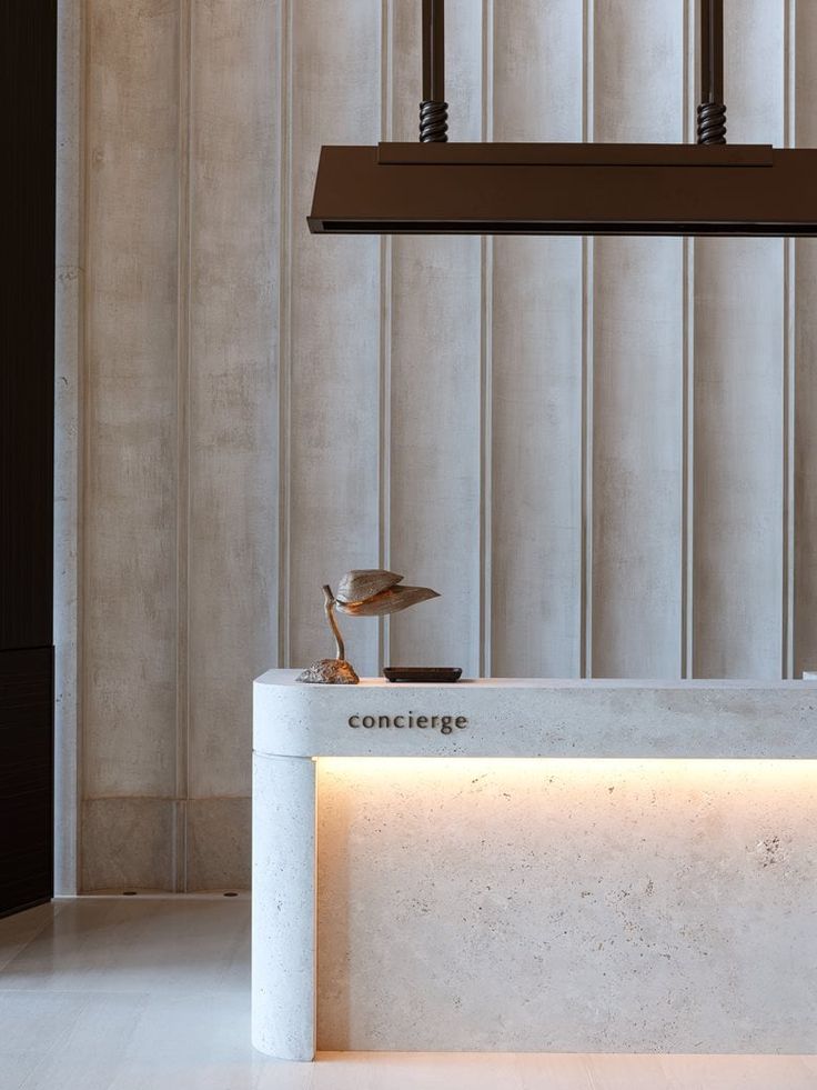 a white counter top sitting under a chandelier next to a wall mounted light