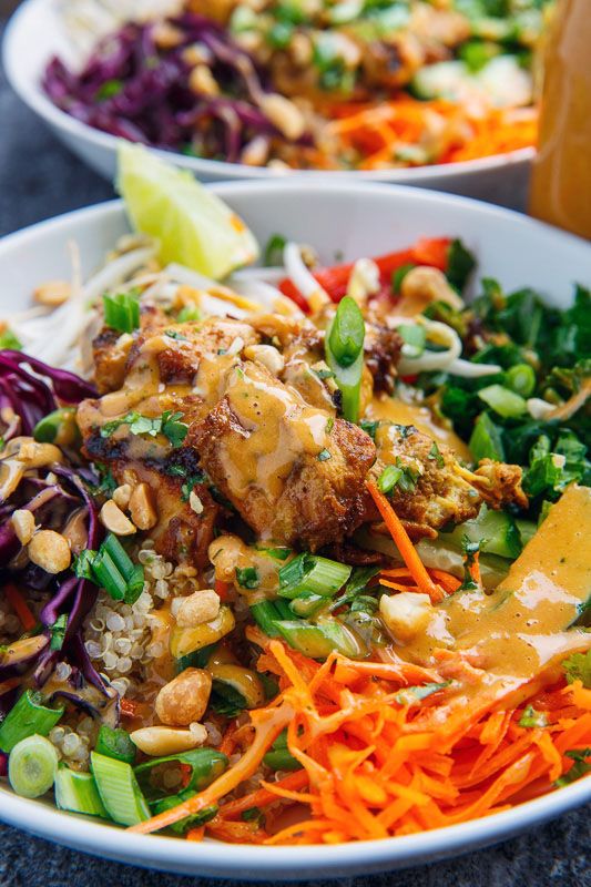 two white bowls filled with different types of vegetables and meat on top of each other