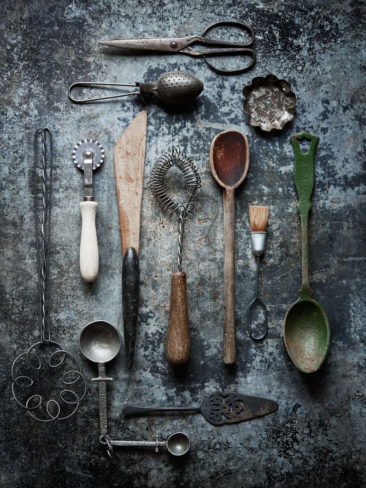 an assortment of kitchen utensils and spoons laid out on a gray surface