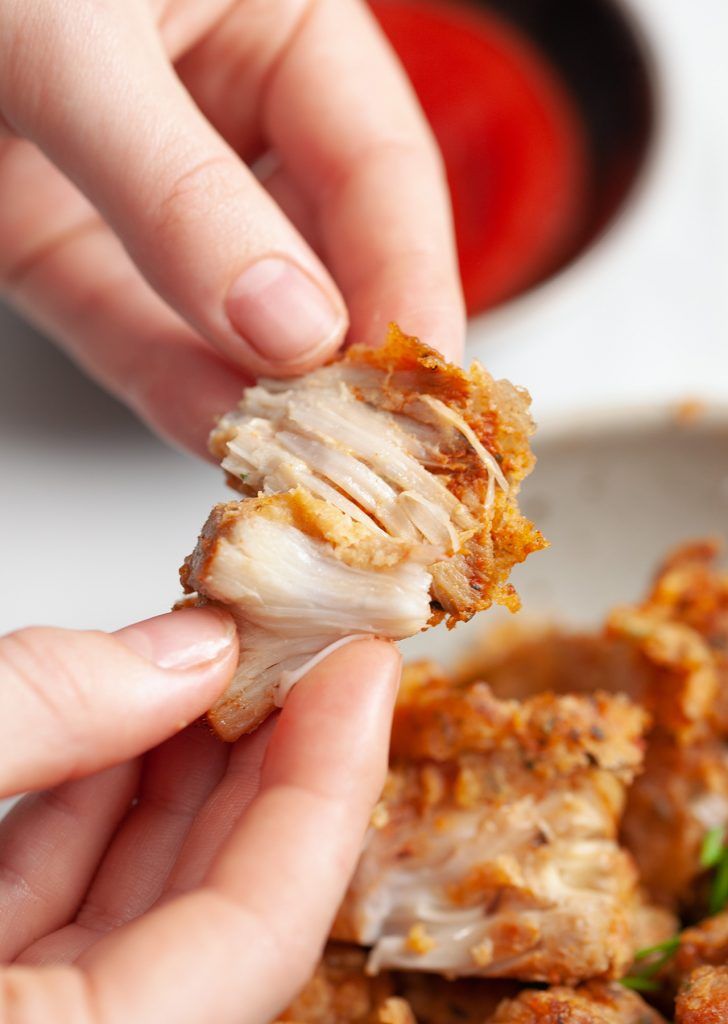 a person is picking up some food from a plate