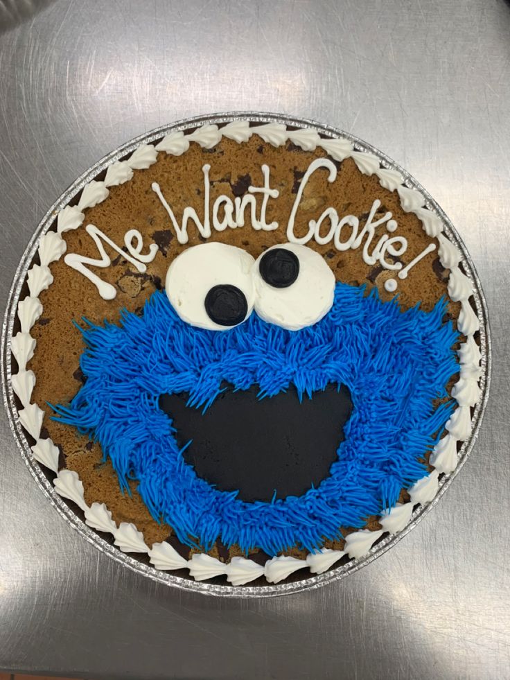 a cookie cake decorated with blue icing and an image of a cookie monster's face