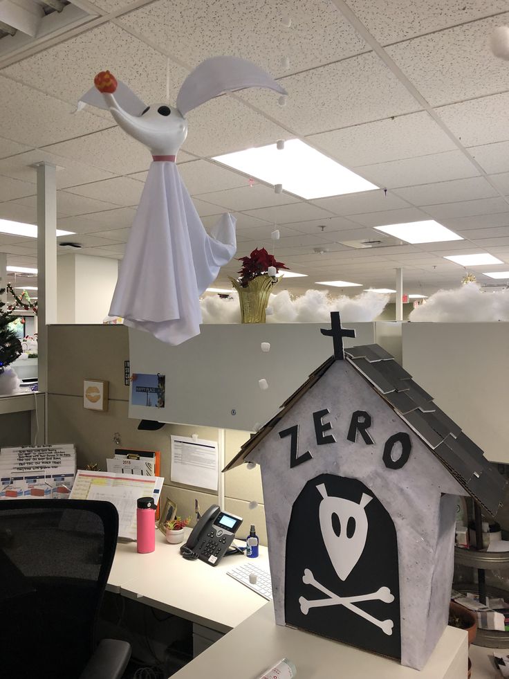 an office cubicle decorated for halloween with ghost and skull decorations hanging from the ceiling