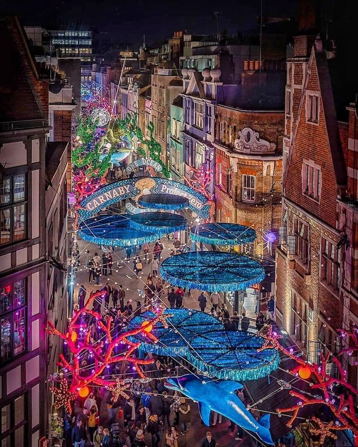 an aerial view of a city at night with many lights and decorations on the buildings